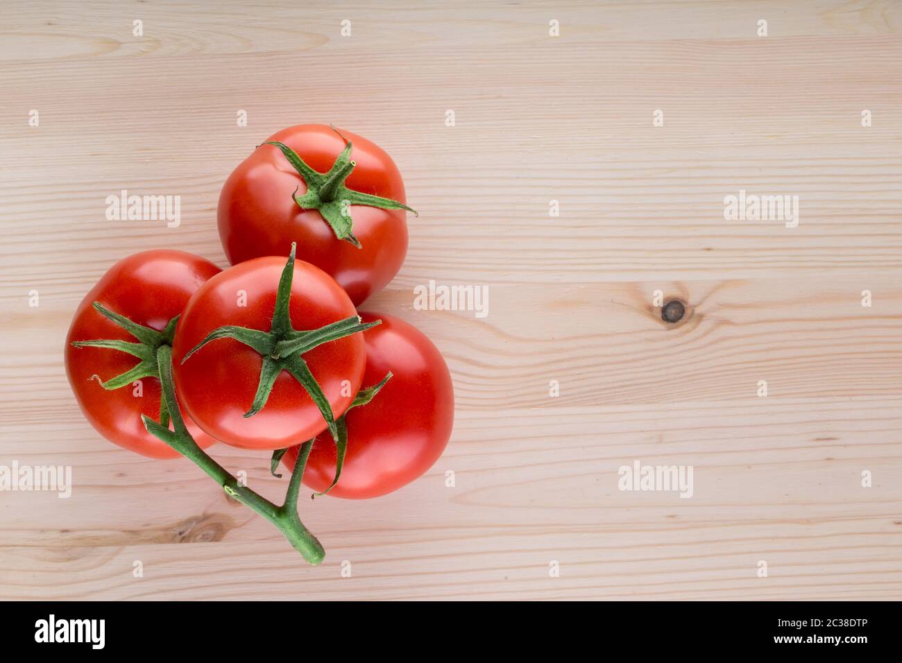 Bunch of ripe tomatoes on a wooden table Stock Photo - Alamy