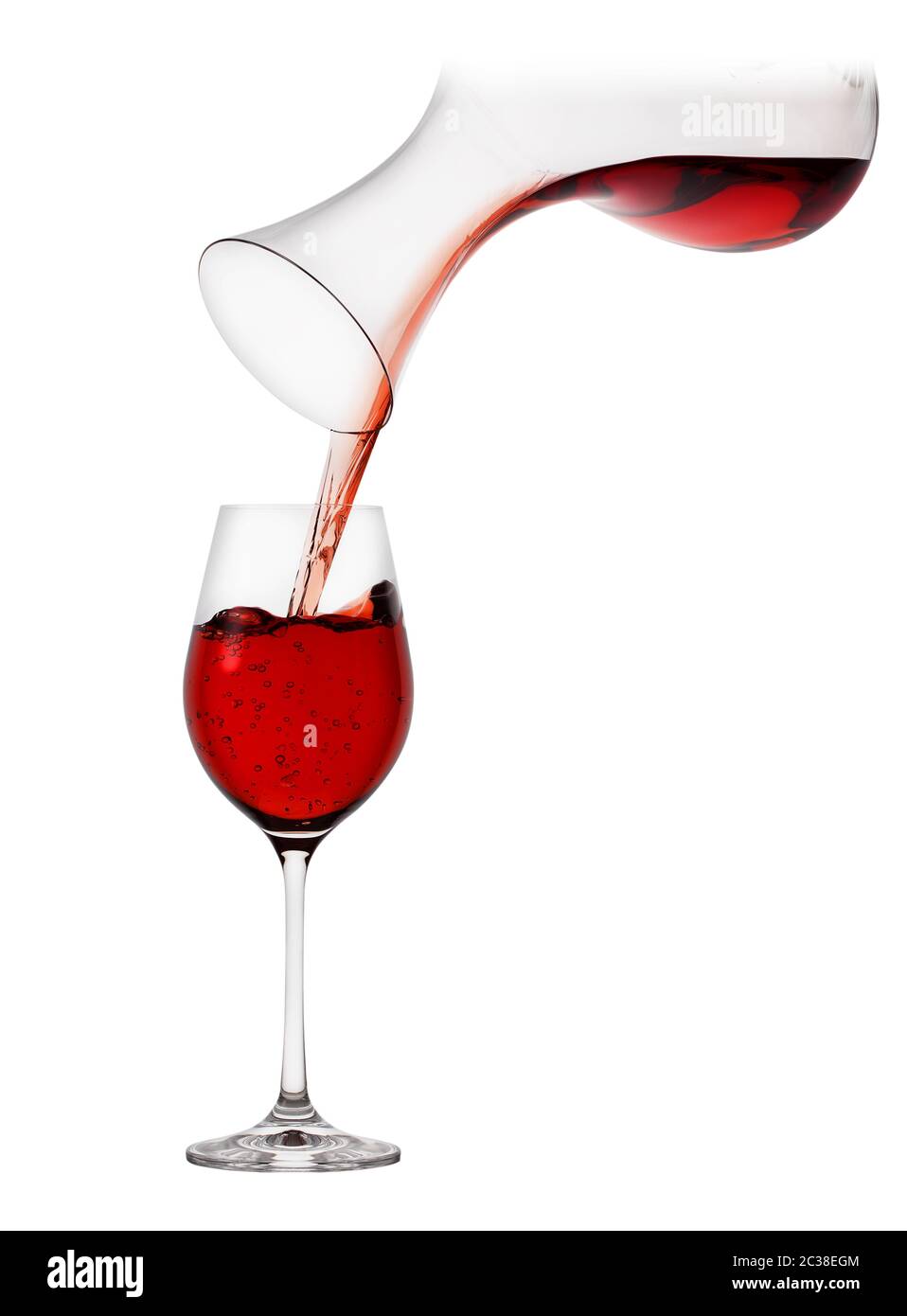 Red wine pouring from decanter into a glass isolated on white