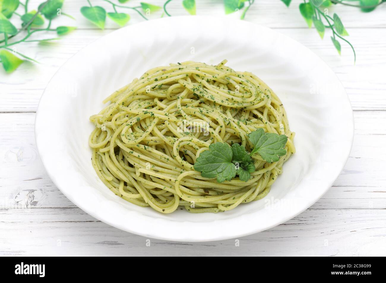 Pasta spaghetti with fresh basil leaves, cream and cheese on table Stock Photo