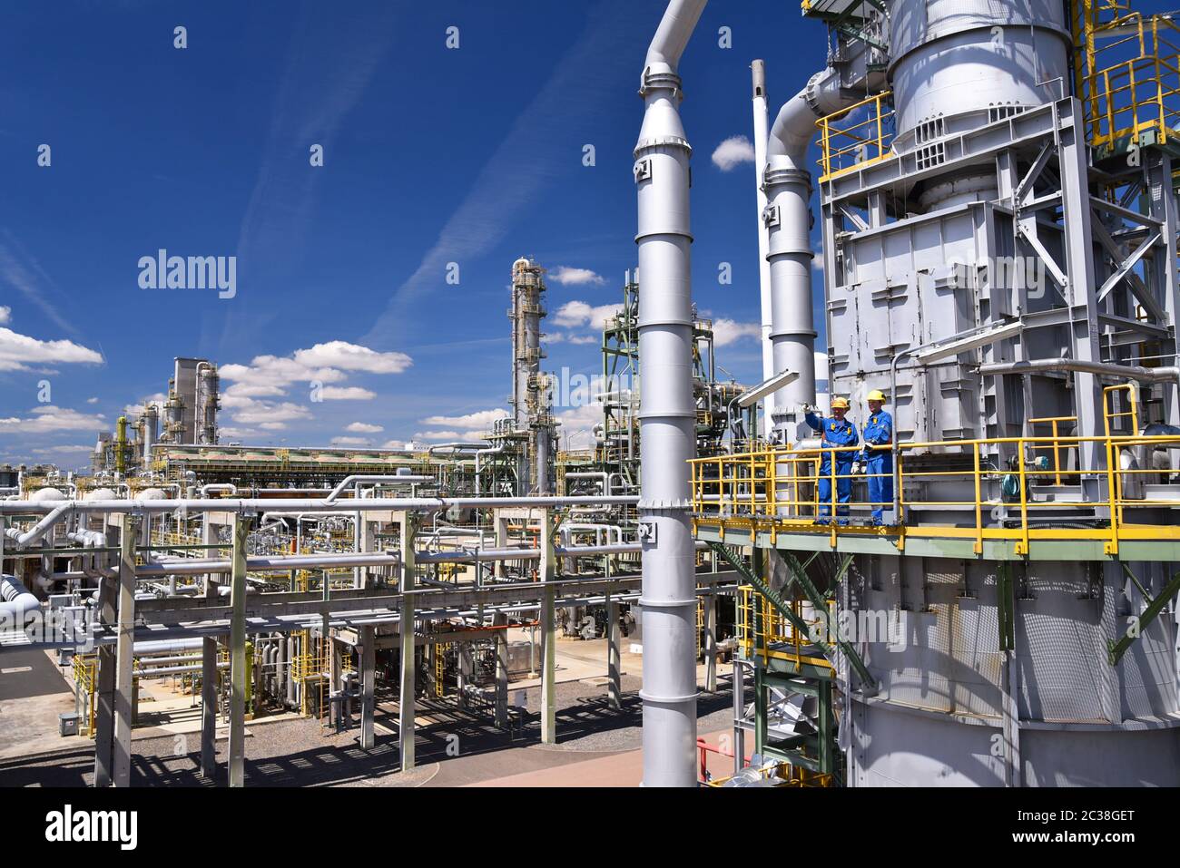 group of industrial workers in a refinery oil processing equipment