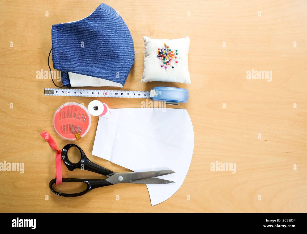 Tabletop view of sewing equipment to make your own protective Coronavirus face mask, wooden background, needlecraft DIY project. Stock Photo