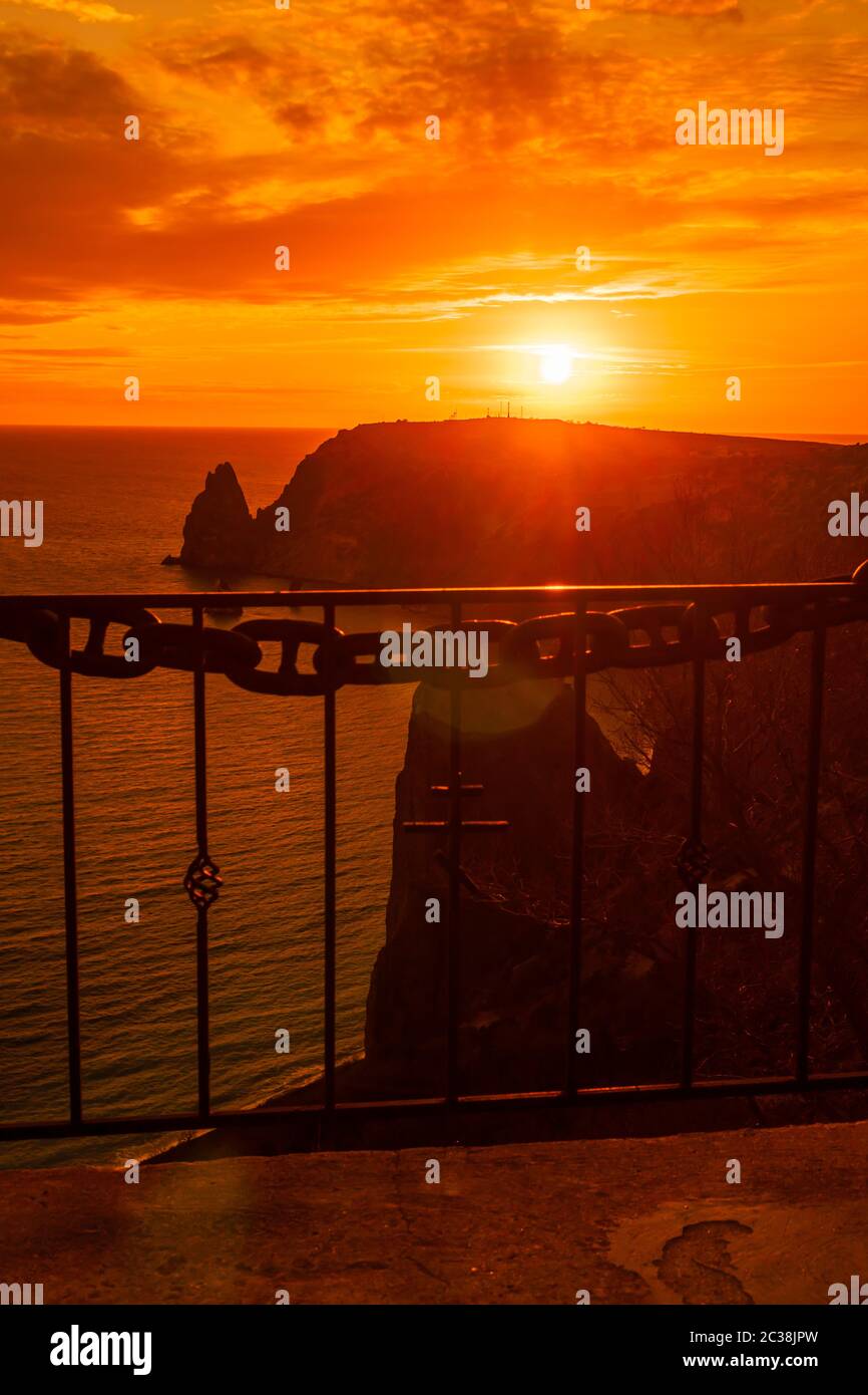 A red burning sunset with the silhouett of cape Fiolent and cliff over ...