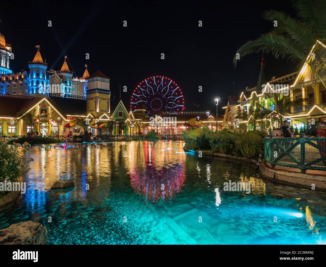 Artificial pond with lighting in the evening on background of the attraction. Russia Sochi 06 22 2019 Stock Photo