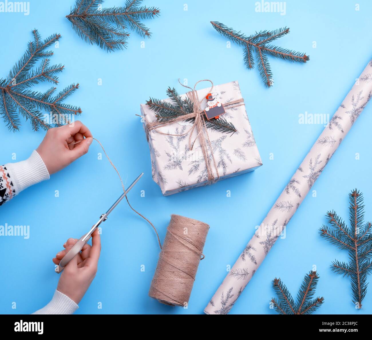 gift wrapped in pink paper and tied with a brown rope, female hand with ...