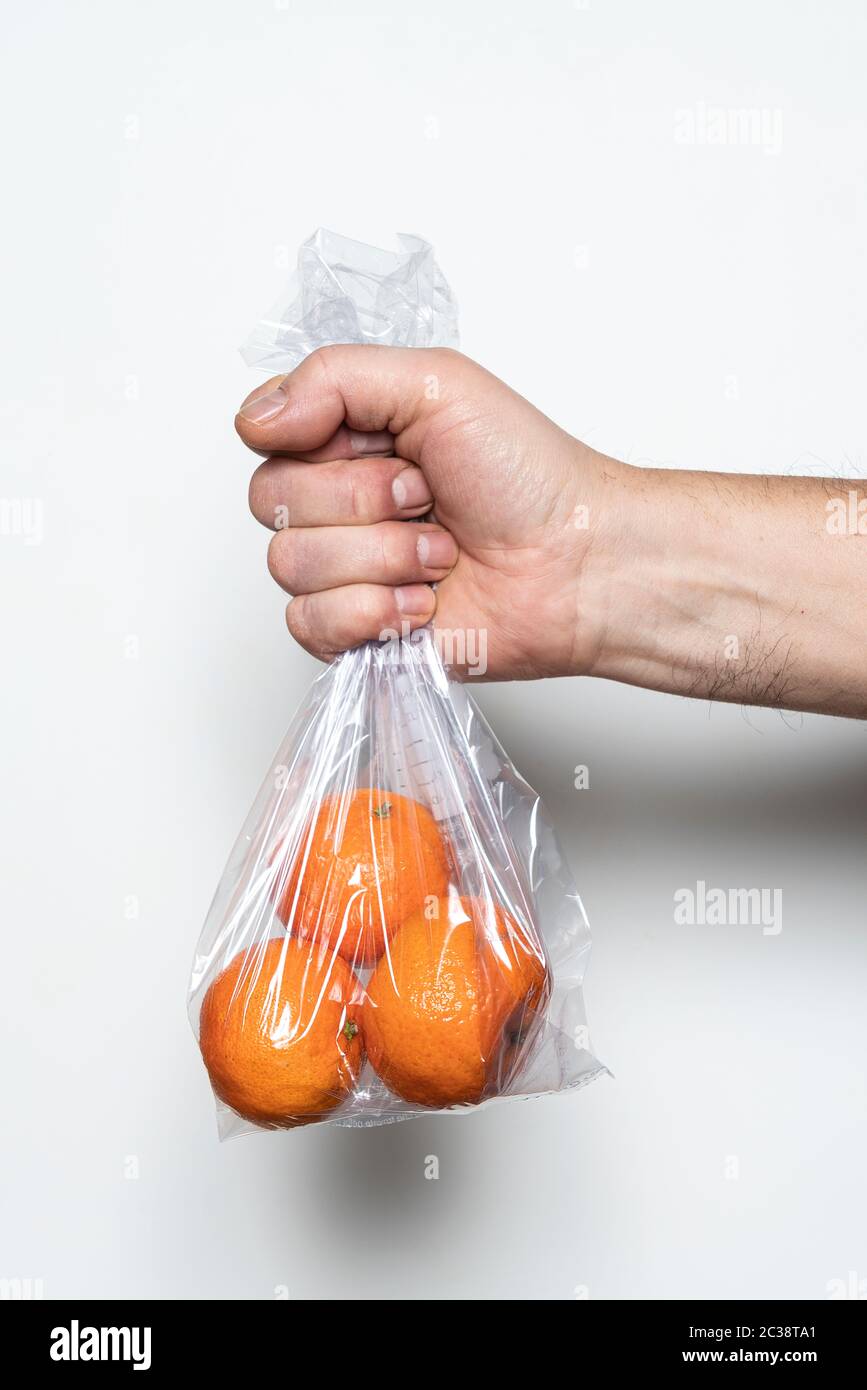 Fresh tangerines with leaves in a plastic bag Stock Photo