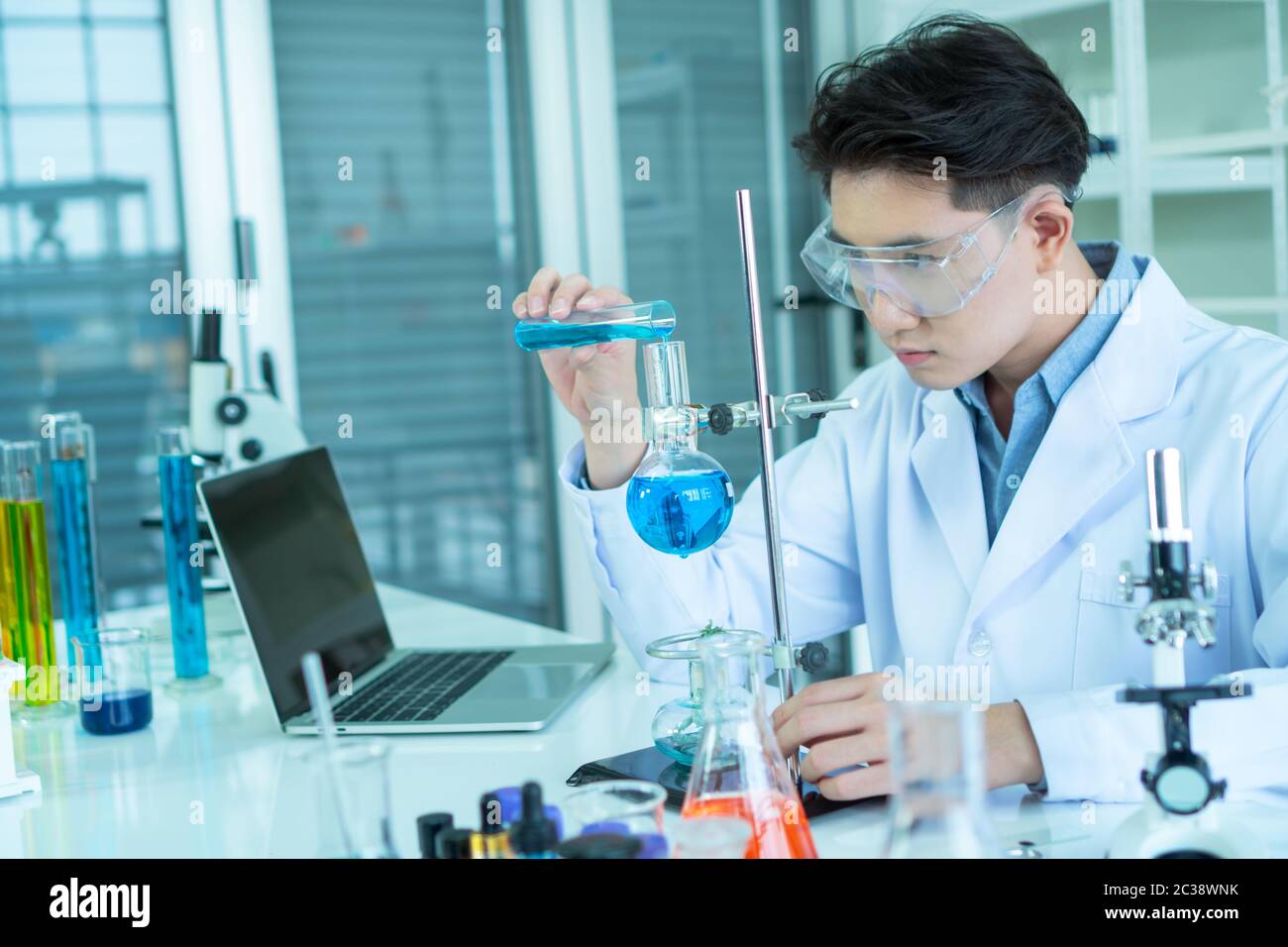 An Asian male scientist is experimenting with the search for medicine. In the lab Stock Photo