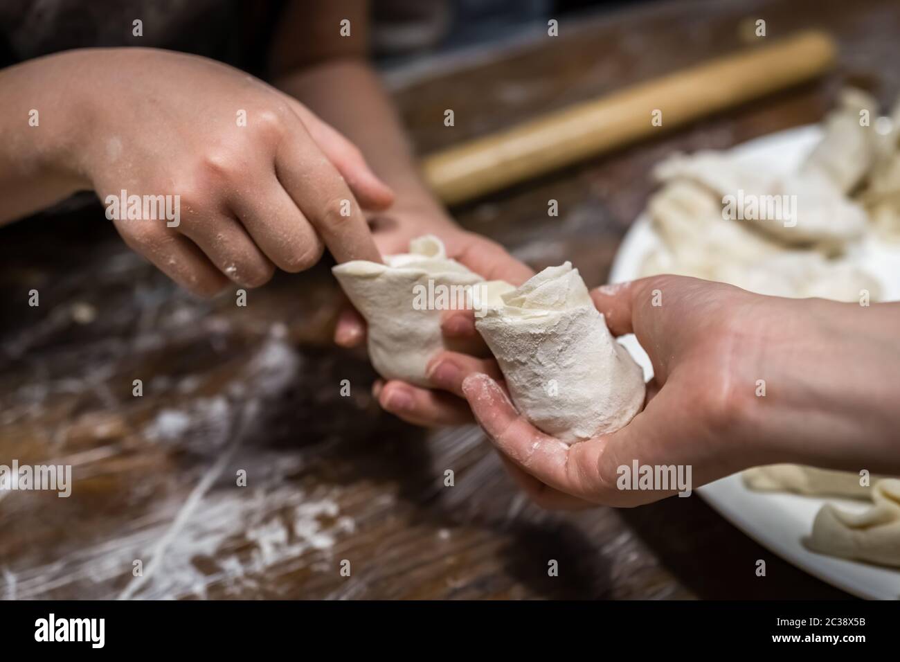 Students learning how to shape chinese dumplings Stock Photo
