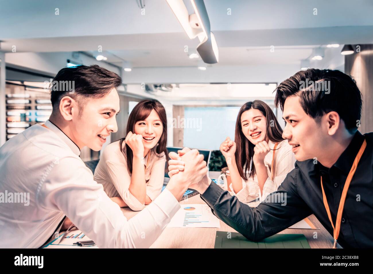 Businessman Competing In Arm Wrestling  at office Stock Photo