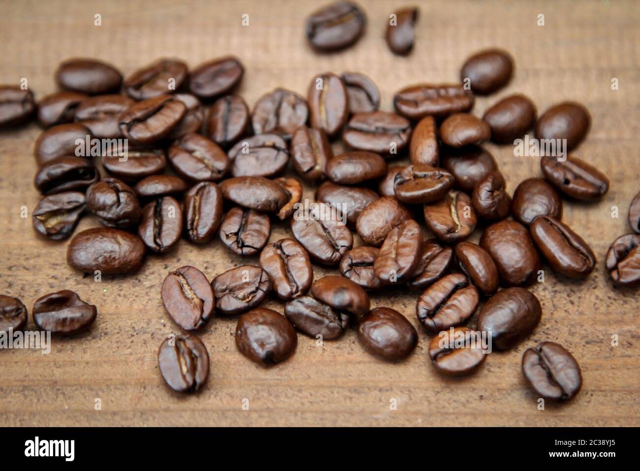 Coffee beans spilled on a board Stock Photo