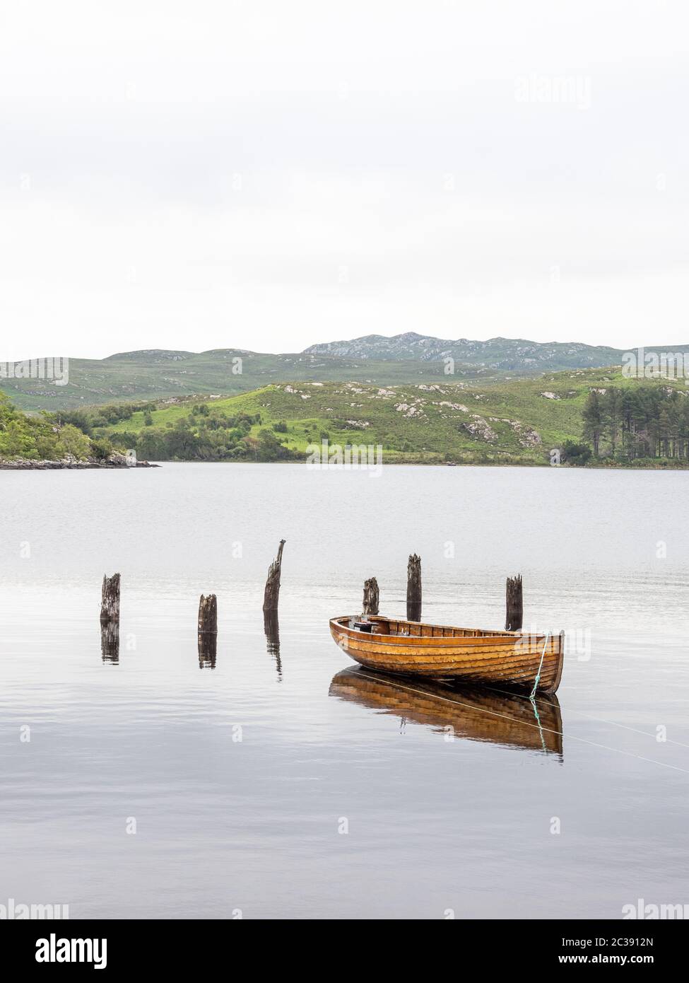 Wooden hulled boat moored at the old jetty Tollie Bay, Loch Maree ...
