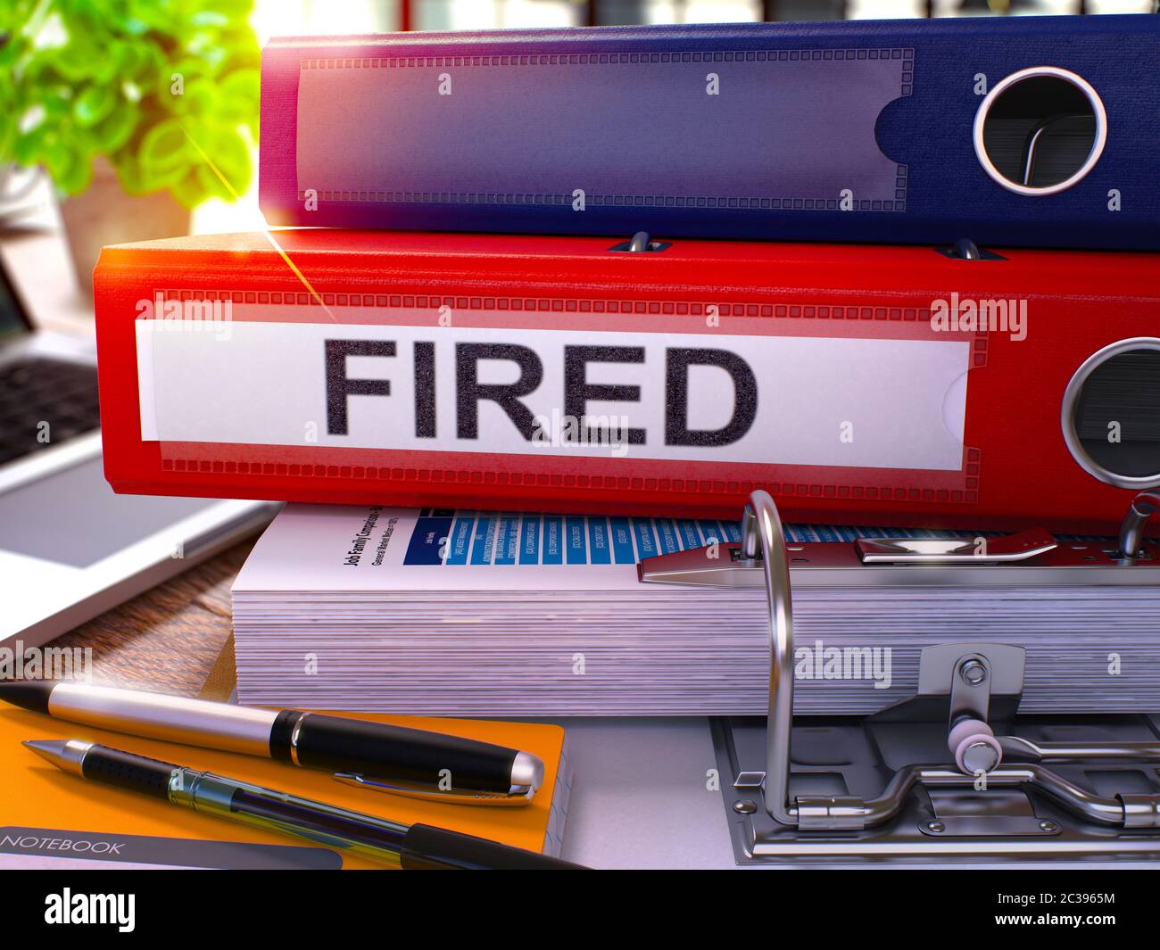 Red Ring Binder with Inscription Fired on Background of Working Table with Office Supplies and Laptop. Fired - Toned Illustration. Fired Business Conc Stock Photo