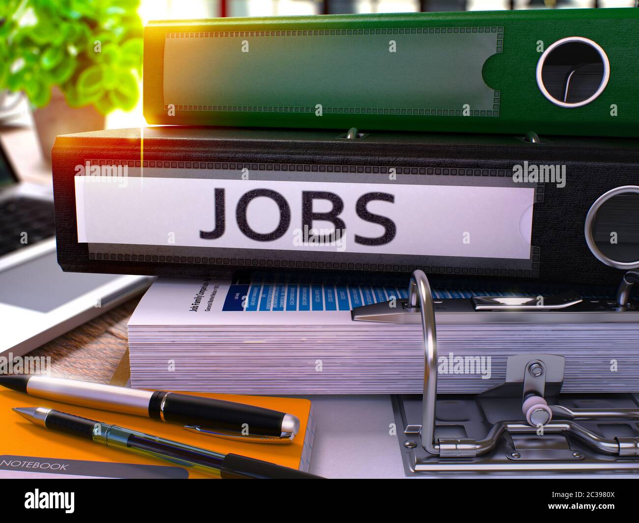Black Office Folder with Inscription Jobs on Office Desktop with Office Supplies and Modern Laptop. Jobs Business Concept on Blurred Background. Jobs Stock Photo