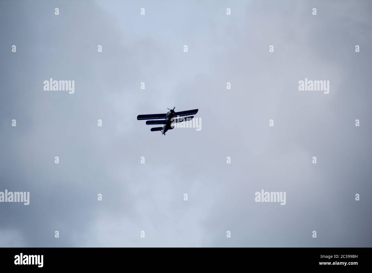 a biplane flies in the sky, probably an AN 2 Stock Photo - Alamy