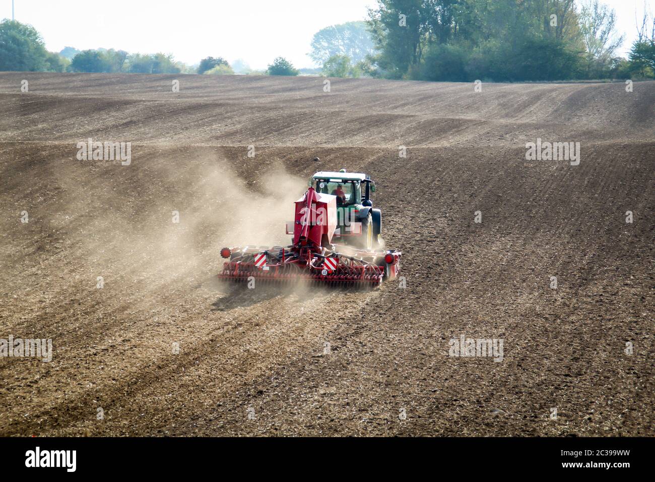 a tractor works its field for the next season in autumn Stock Photo