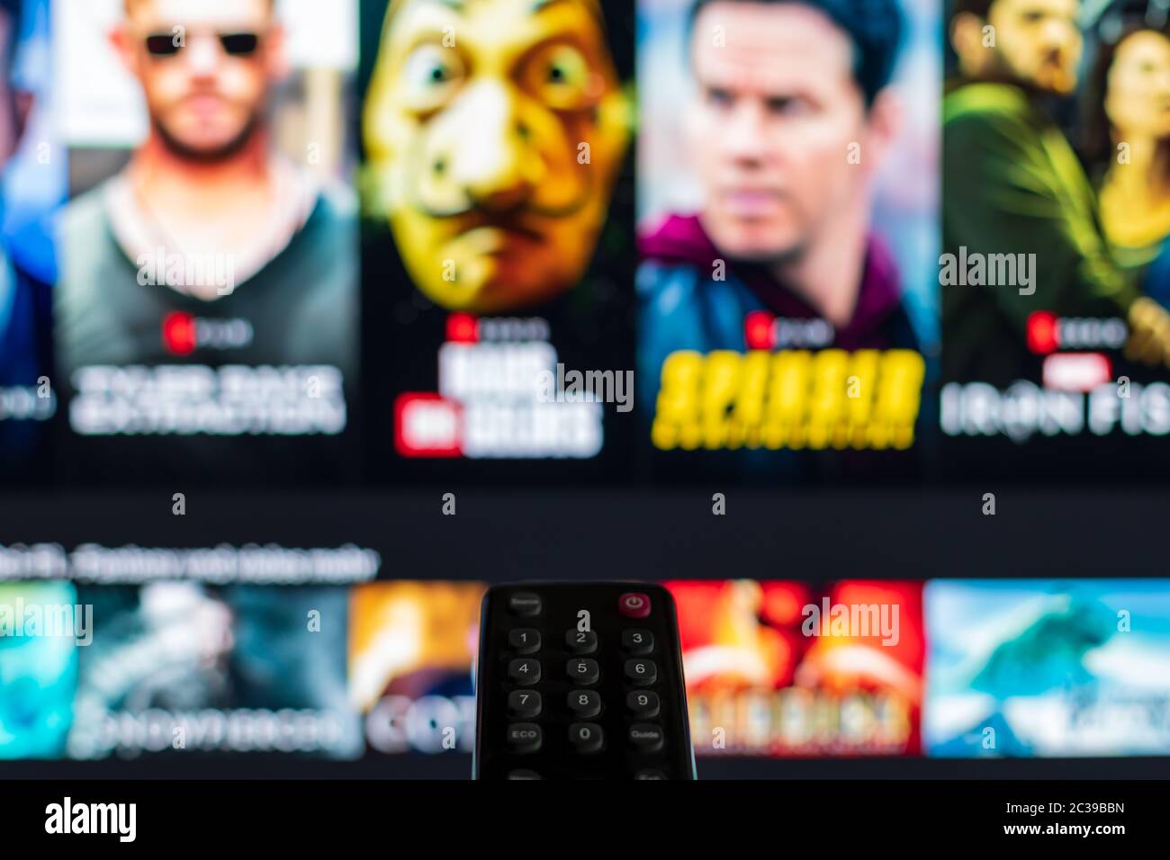 Video on demand screen with remote control in the foreground Stock Photo