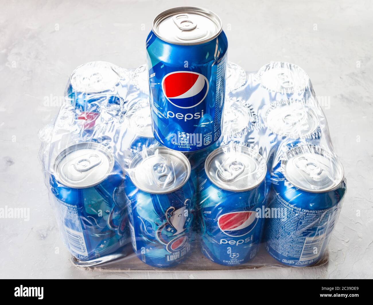 MOSCOW, RUSSIA - JUNE 17, 2020: closed can of Pepsi with logo of UEFA Champions League stays pack of dozen cans on concrete floor. Pepsi is carbonated Stock Photo