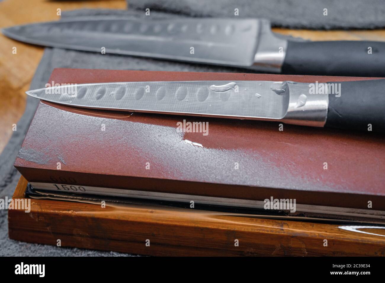 Selective focus on the blade of a steel kitchen knife lying on a water