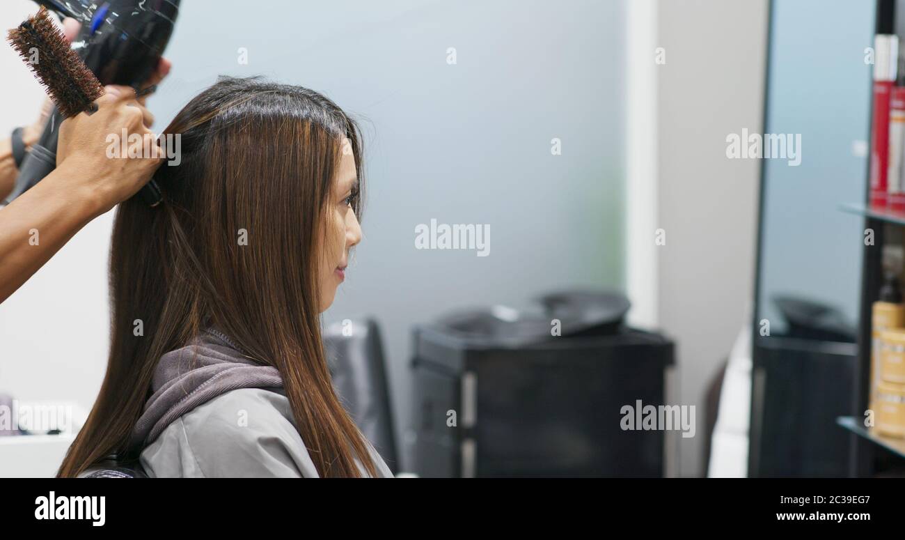 Hair stylist dry hair in hair salon Stock Photo - Alamy