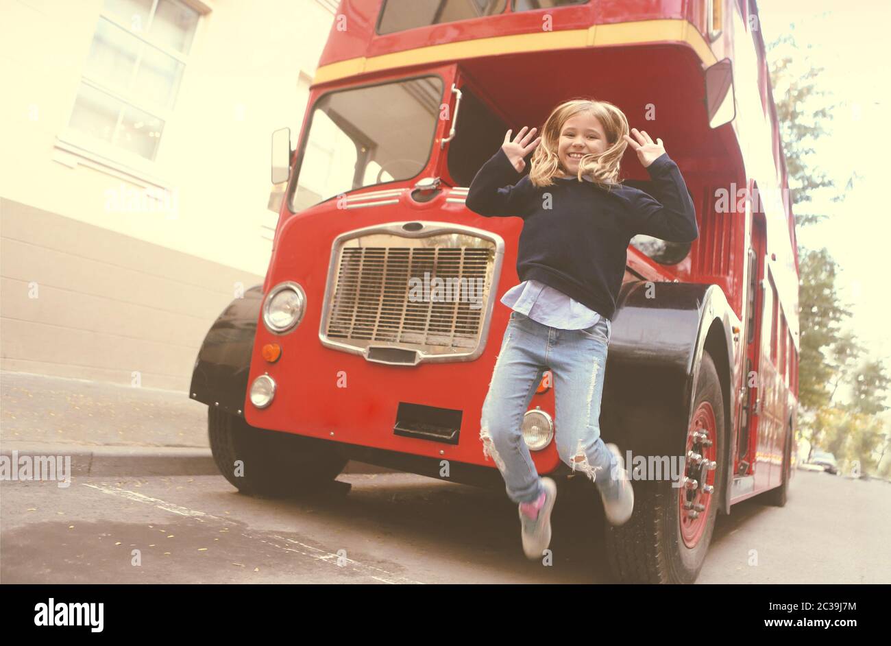 Preteen girl by the red bus Stock Photo