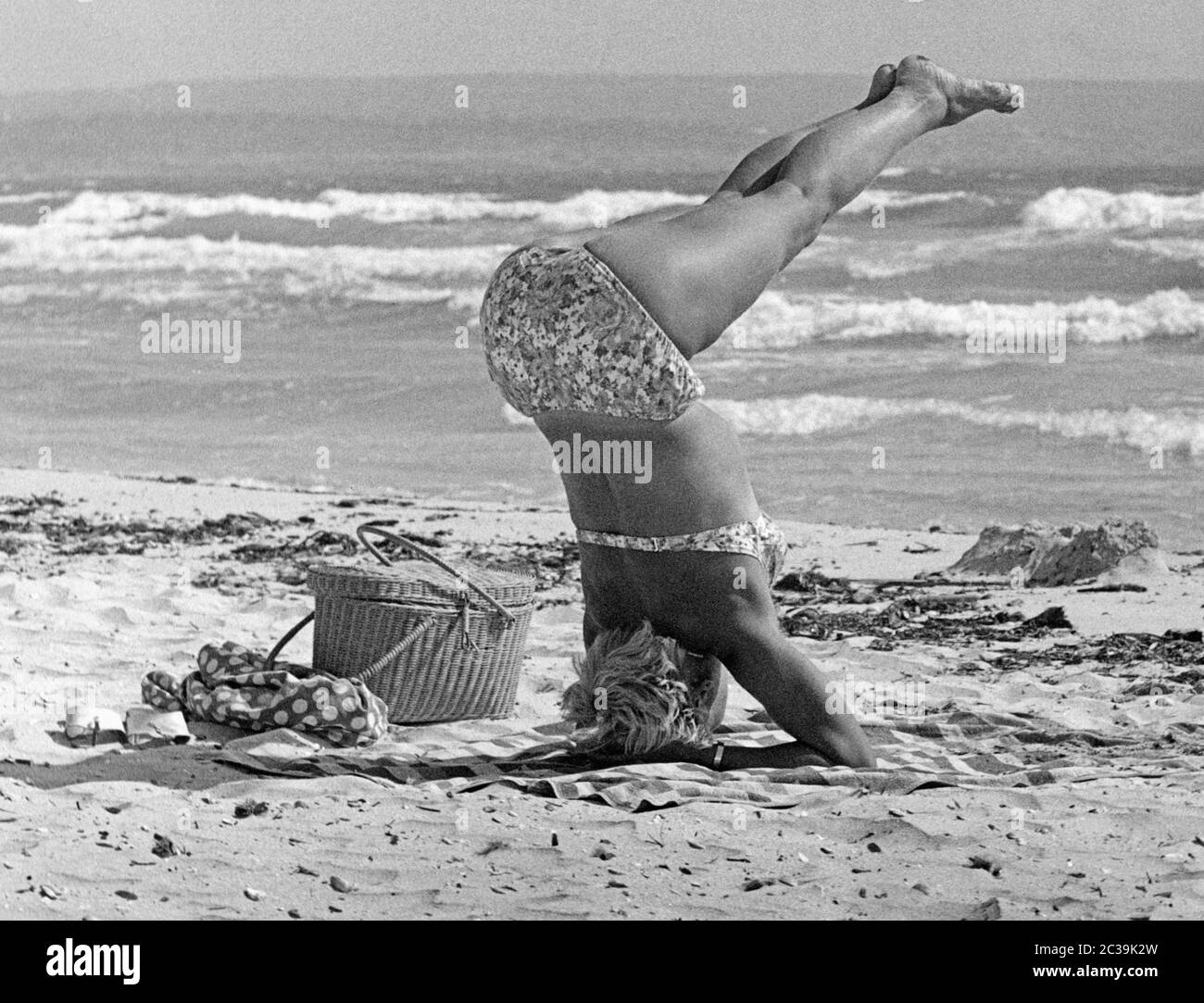 A woman in bikini performs a yoga exercise on the beach of Mallorca Stock  Photo - Alamy