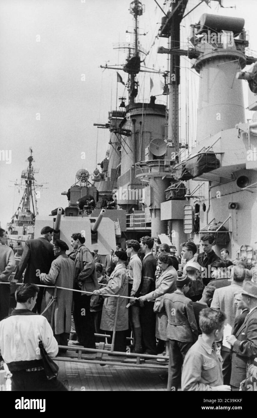 An American cruiser arrived in Hamburg for a visit (1950s). Spectators and visitors crowd on deck of the ship. Stock Photo