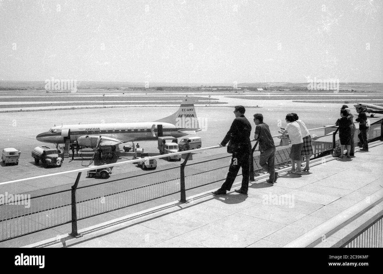 Passengers look at the runway at the Madrid Airport. Stock Photo