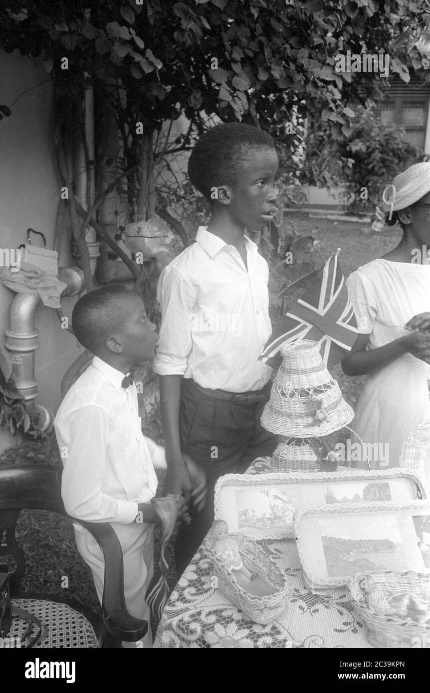 Children from Antigua at a table with the British flag. The Caribbean island was part of the British colonial empire until 1981. The photo was taken during Queen Elizabeth's visit to Antigua in 1966. Stock Photo