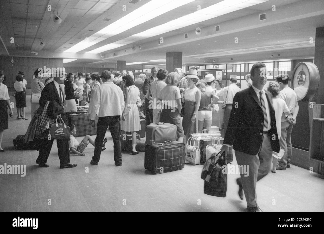 Air travellers stand at the baggage check-in at the Madrid airport. Stock Photo