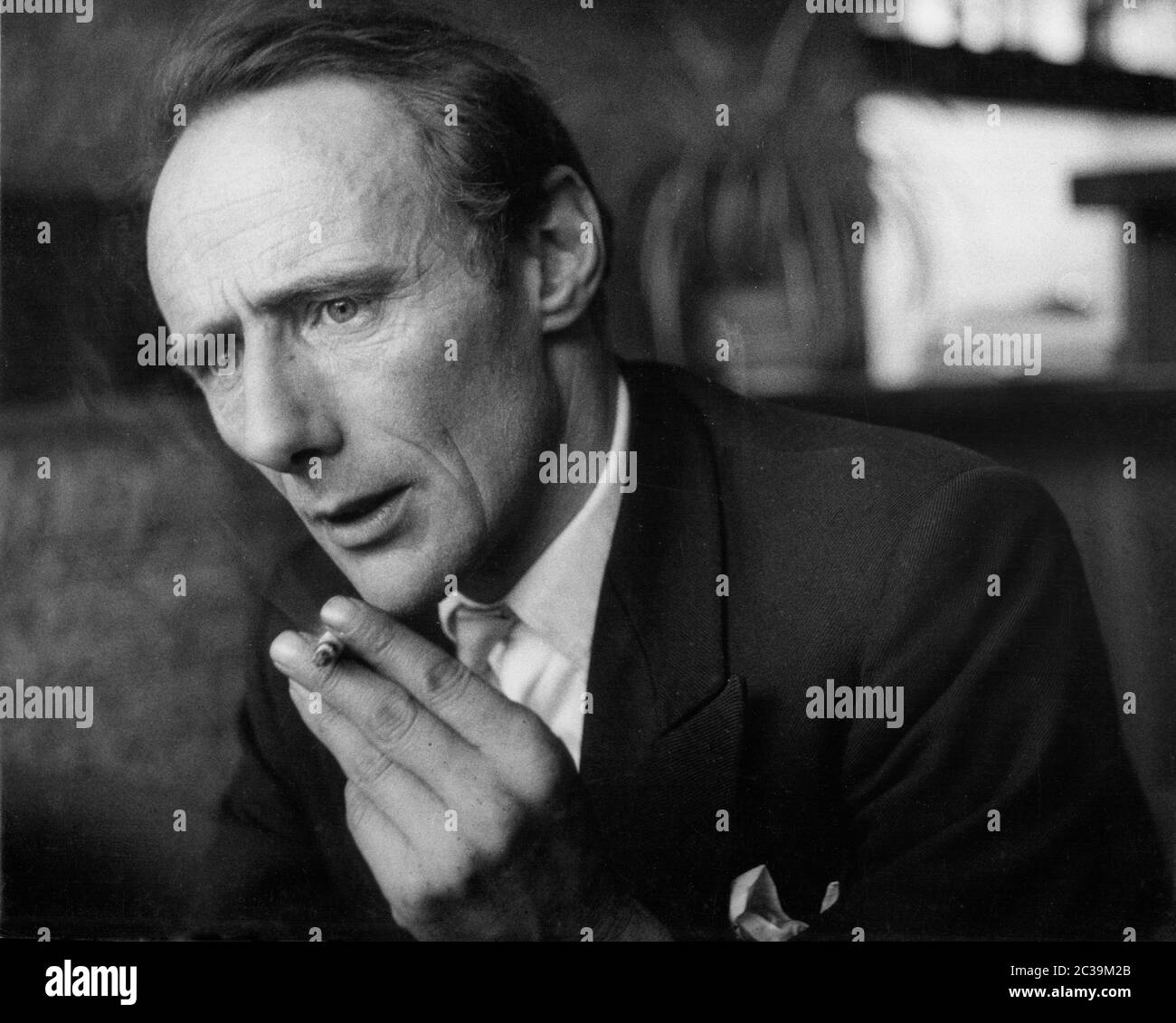 Close up of a man in a suit smoking a cigarette. The picture was taken from a report called 'Wie geht es Ihnen Herr Hansen?' ('How are you, Mr. Hansen?'). Undated photo. Stock Photo