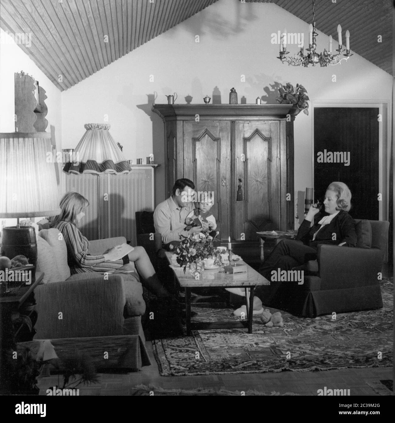 A family is sitting in the living room. Undated photo. Stock Photo