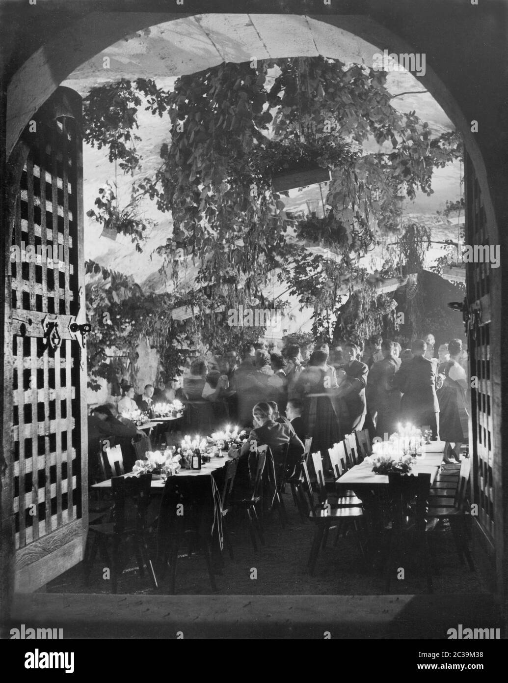 A festive event in a restaurant. Some of the women wear Bavarian dirndls. Undated photo. Stock Photo