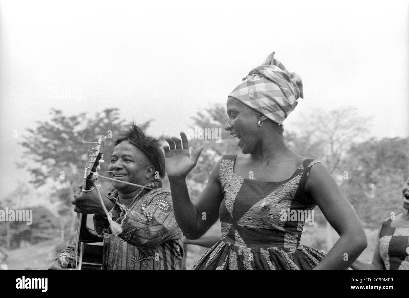 In Sierra Leone, a man plays the guitar while a woman dances to it. Stock Photo