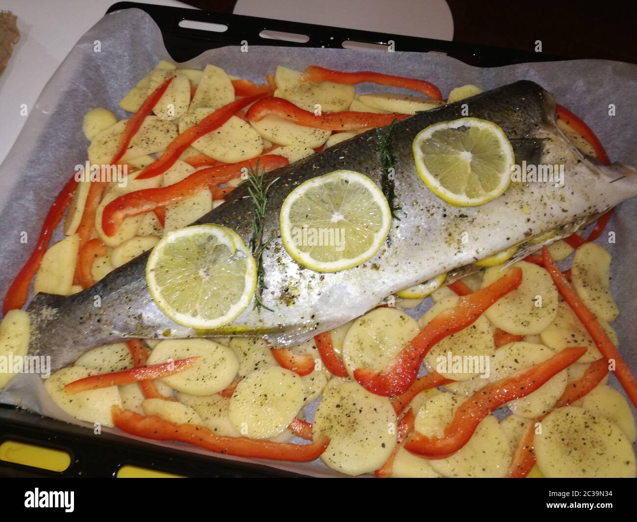Sea bass with potatoes and peppers ready for the oven Stock Photo Alamy