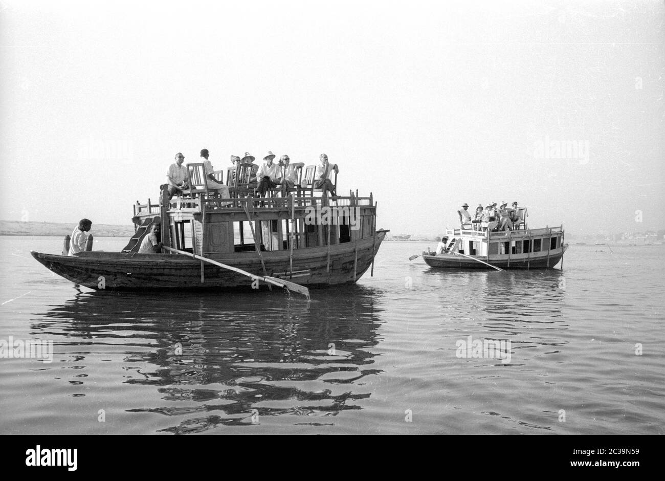 European visitors on wooden rowing boats on the Ganges in the north Indian city of Benares, also
