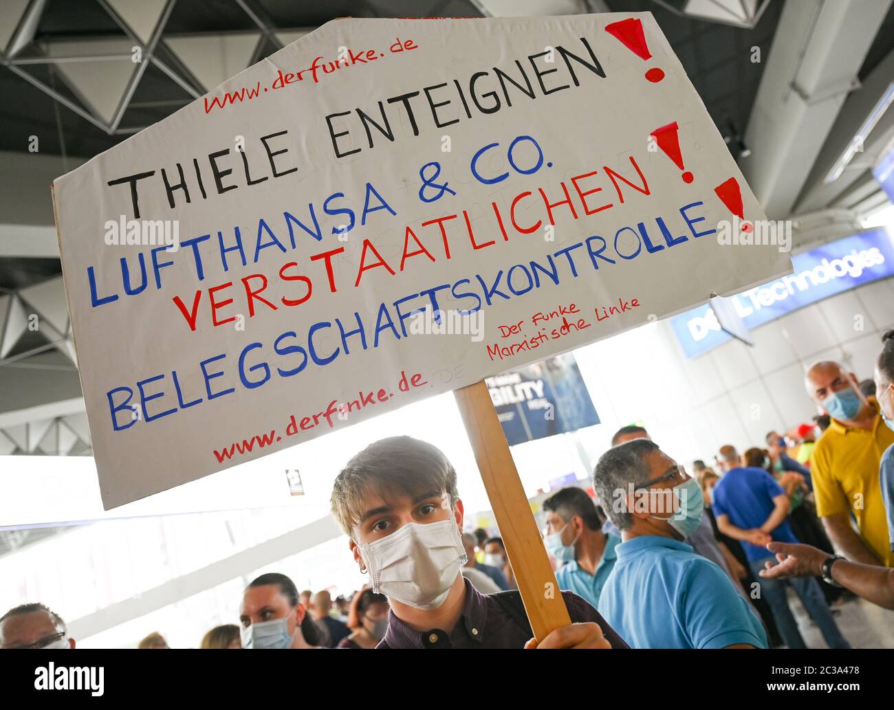 19 June 2020, Hessen, Frankfurt/Main: During a protest action by air traffic employees in Terminal 1 of Frankfurt Airport, a man holds a poster with the words "Expropriate Thiele! Lufthansa & Co nationalize! Employee Control!". The Verdi union has called for a nationwide demonstration to draw attention to the situation of ground handling workers. Photo: Arne Dedert/dpa Stock Photo