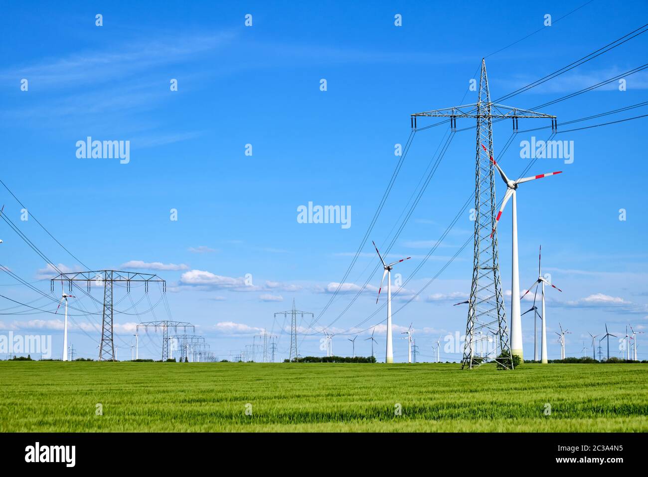 Wind power plants and overhead power lines seen in Germany Stock Photo
