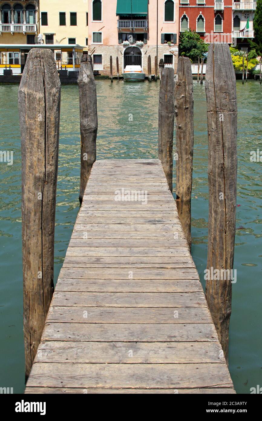 Wooden pier with old columns in Venice canal Stock Photo - Alamy