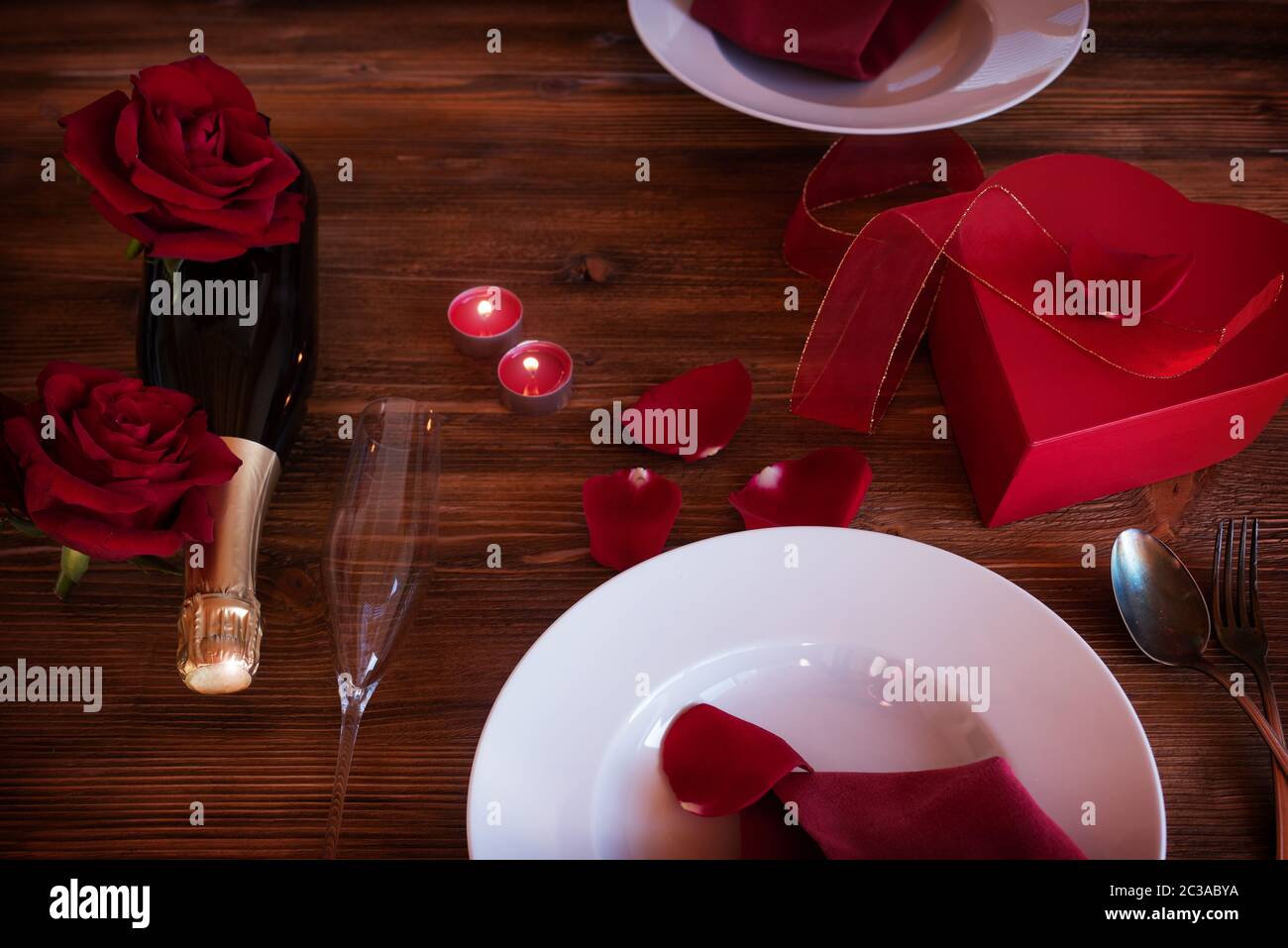 Romantic valentines day table setting with a surprise gift, champagne ...
