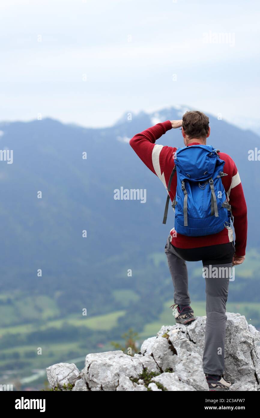 a hiking man is standing on a top of a mountain Stock Photo