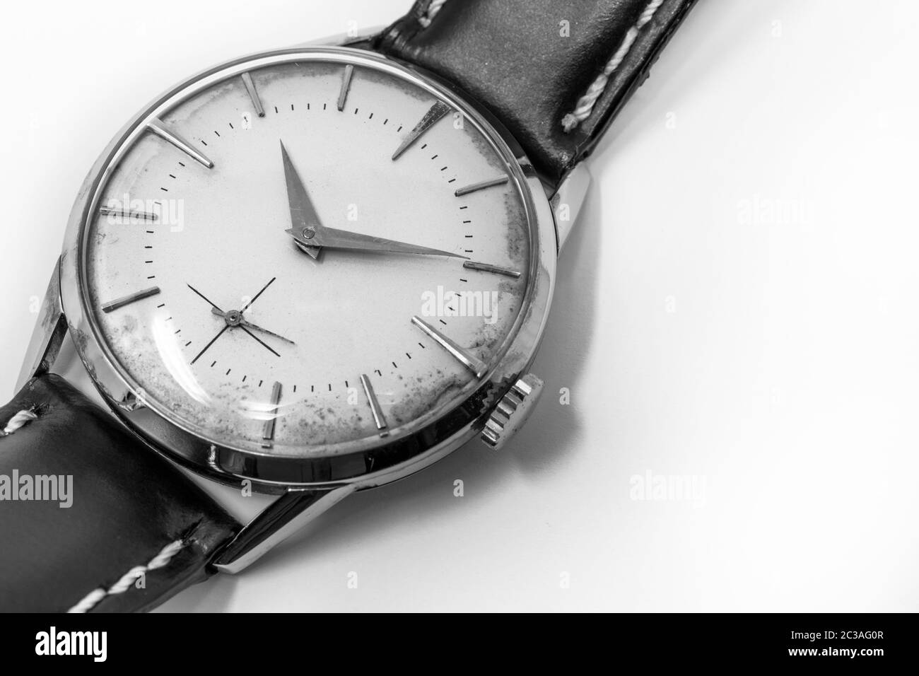 An old gold mechanical wristwatch with manual winding. Antique watch ruined by time, with scratches and mildew stains, rust, oxidation. Leather strap Stock Photo