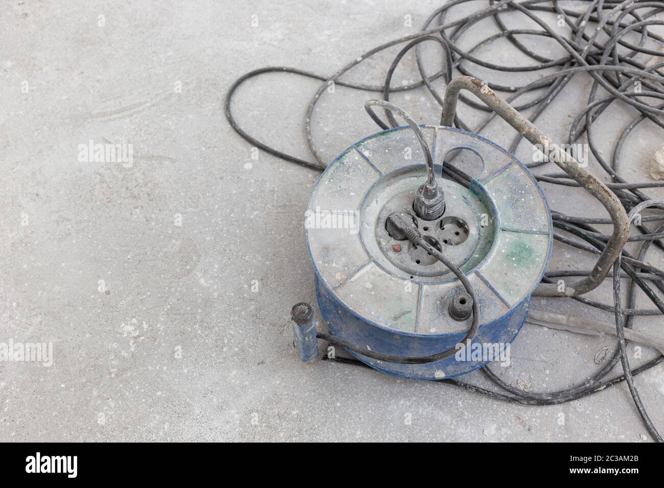 Dirty Electrical extension cord or cable spool with plugs on