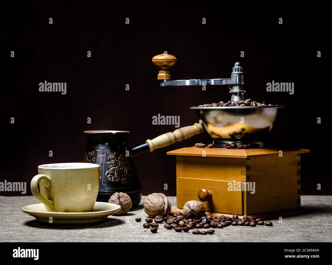 https://c8.alamy.com/comp/2C3AMAN/coffee-cup-with-a-cezve-and-coffee-grinder-with-coffee-beans-and-nuts-on-a-dark-background-2C3AMAN.jpg