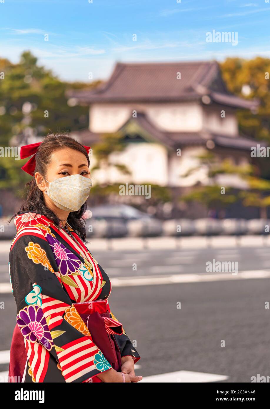 Japanese woman in hakama kimono in front of the dungeon Edojō sakurada tatsumiyagura with moats lined with pine trees outside of the Tokyo Imperial Pa Stock Photo