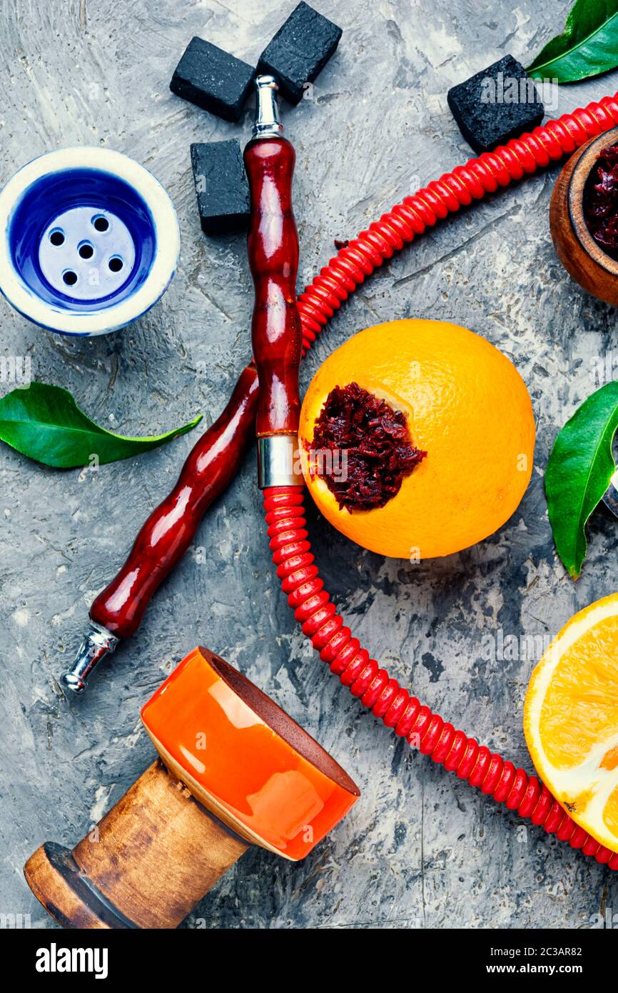 Smoking hookah pipe with mouthpiece and citrus flavored shisha tobacco