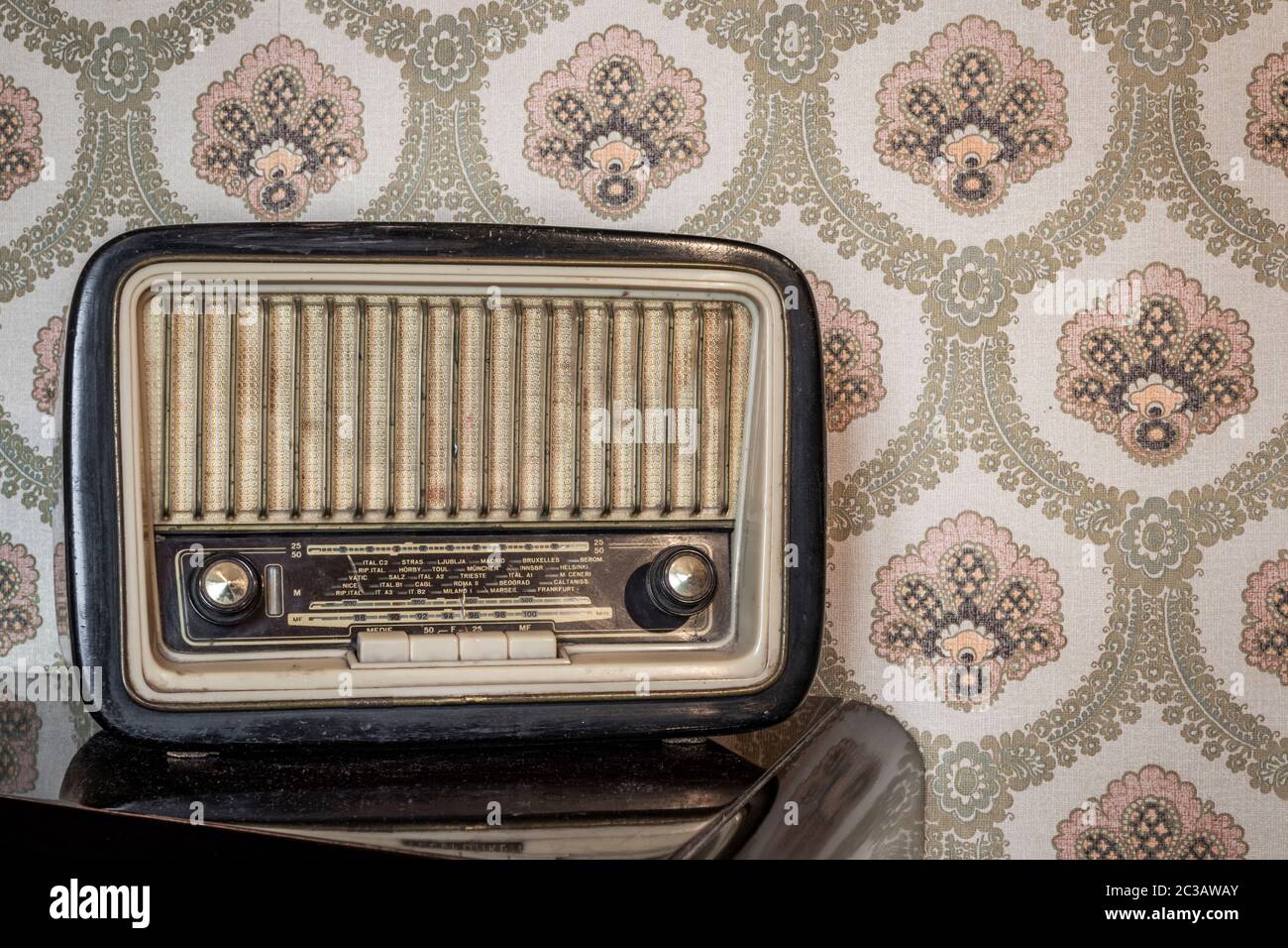 An old transistor radio, with knobs and buttons for manual tuning. In the  background a vintage wallpaper. Ancient object, worn and ruined by time  Stock Photo - Alamy