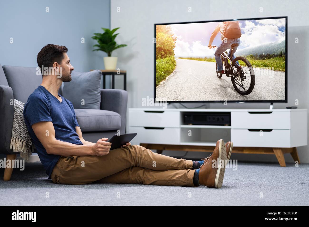 Man Streaming Television Channel Through Wireless Connection On Digital Tablet Stock Photo