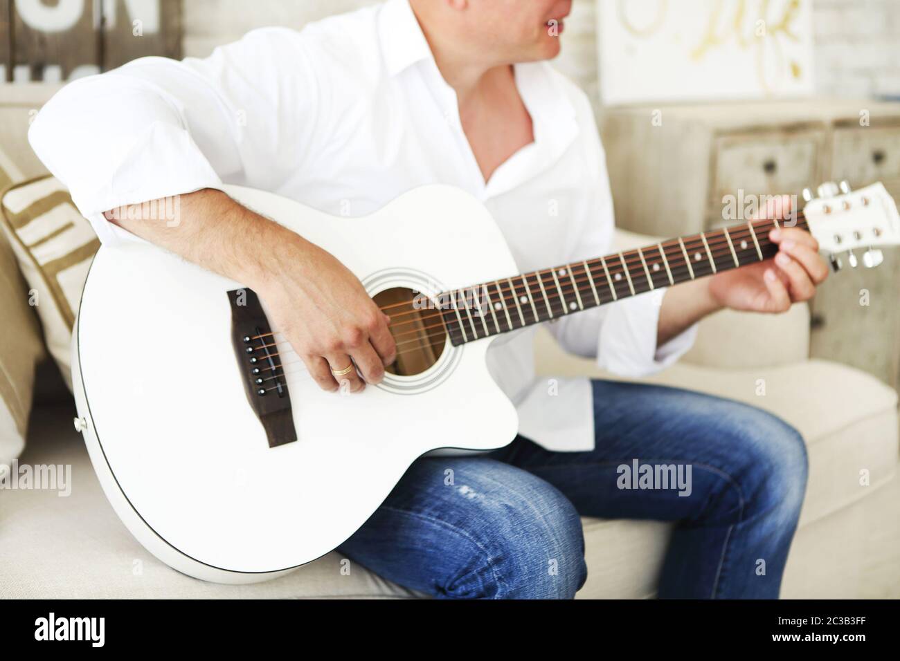 Crop man playing acoustic guitar Stock Photo