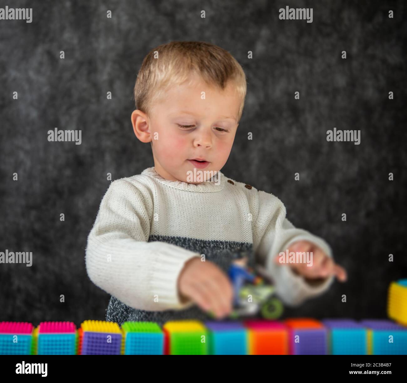 Portrait of cute little boy playing with a motorcycle toy Stock Photo