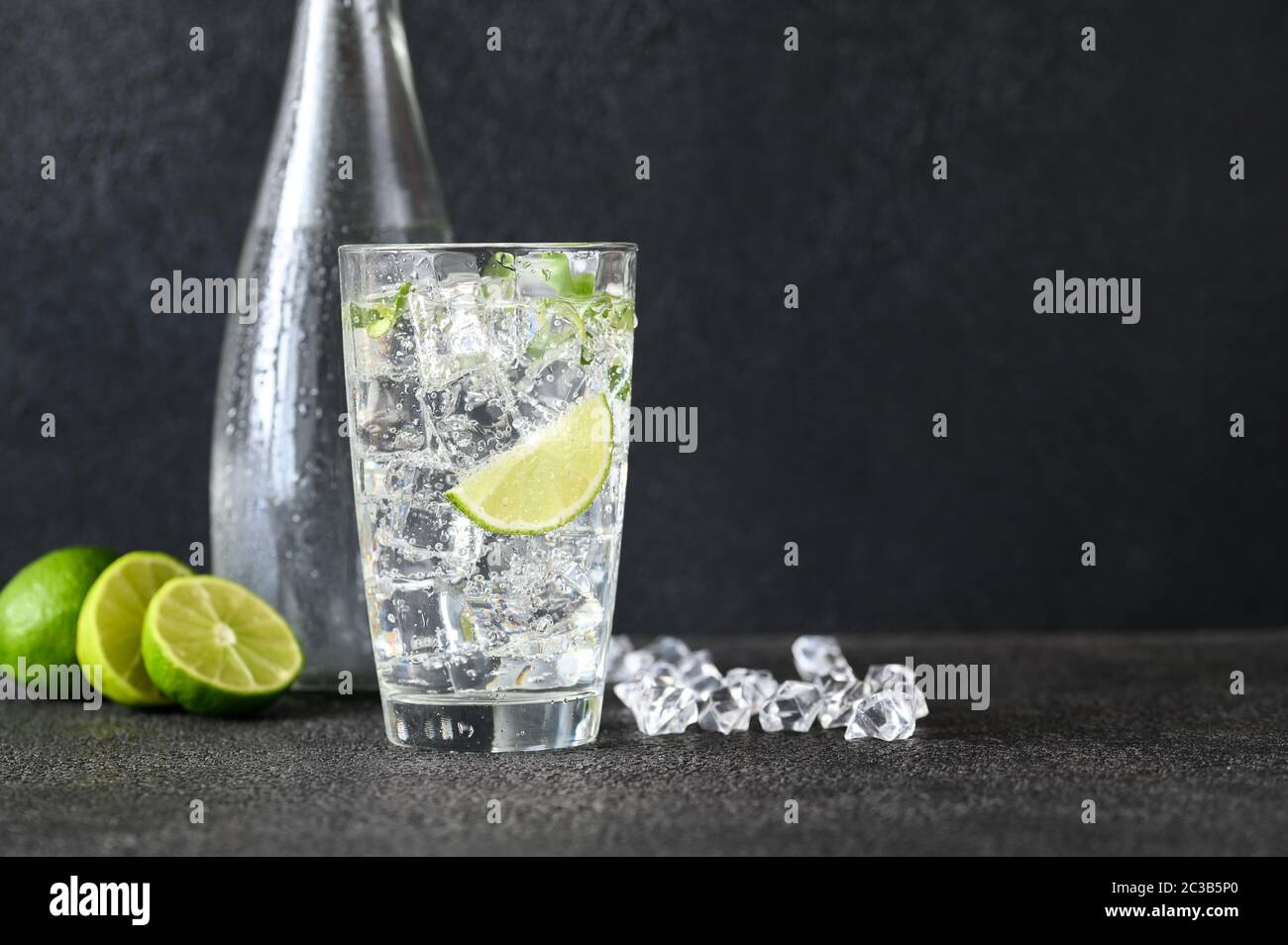 Glass of sparkling water with ice cubes and slice of lime Stock Photo ...