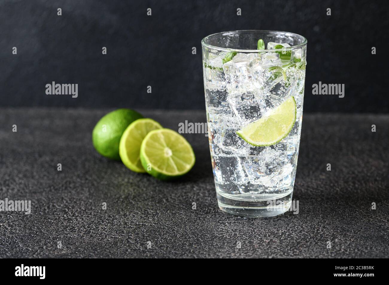Glass of sparkling water with ice cubes and slice of lime Stock Photo ...